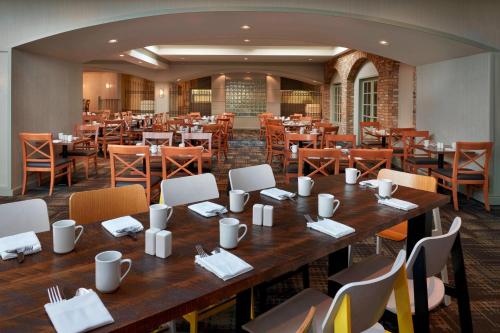 a restaurant with a large wooden table and chairs at Delta Hotels by Marriott Toronto Airport & Conference Centre in Toronto