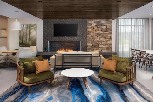 a living room with two chairs and a fireplace at Fairfield Inn & Suites by Marriott Knoxville Lenoir City/I-75 in Lenoir City