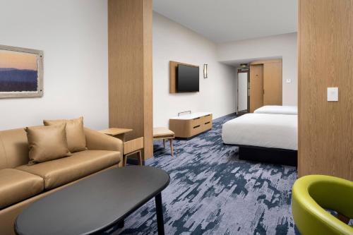 una camera d'albergo con un divano e un letto di Fairfield Inn & Suites by Marriott Knoxville Lenoir City/I-75 a Lenoir City