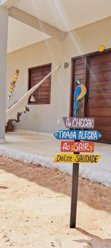 a sign in the sand in front of a house at Chalé sol de Macapá 1- Sua Casa pertinho do Mar in Luis Correia