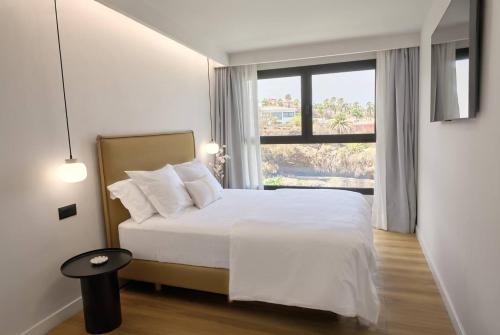 a bedroom with a white bed and a large window at Casa Carlos in Puerto de la Cruz