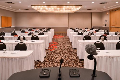 a conference room with white tables and a microphone at Delta Hotels by Marriott Regina in Regina