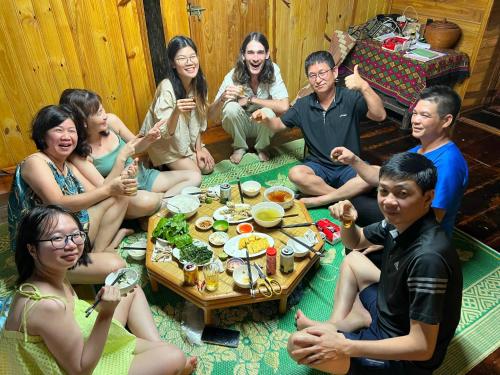 a group of people sitting around a table eating food at Trường Giang homestay Bản Giốc in Dam Thuy