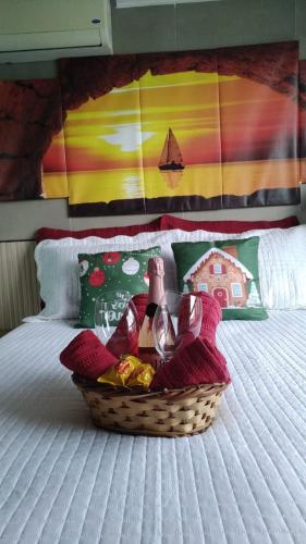 a basket of food and a wine bottle on a bed at Luxor Paulo Miranda Frente ao mar in João Pessoa