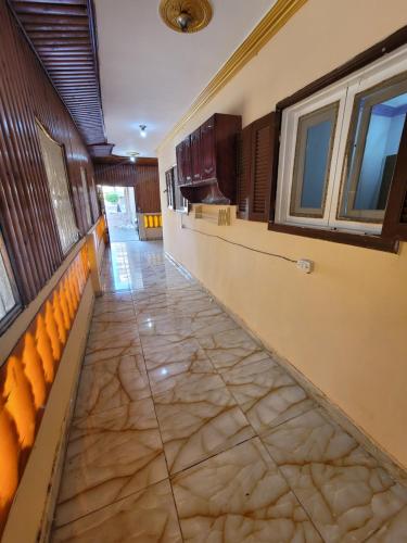 a hallway of a building with a tile floor and windows at جمصه Karnak Gamasa in Jamaşah