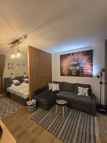 a living room with a couch and a bed at Kai Apartman in Kopaonik