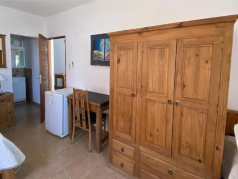 a kitchen with a table and a wooden cabinet at Posada D`Lua in Villa Carlos Paz