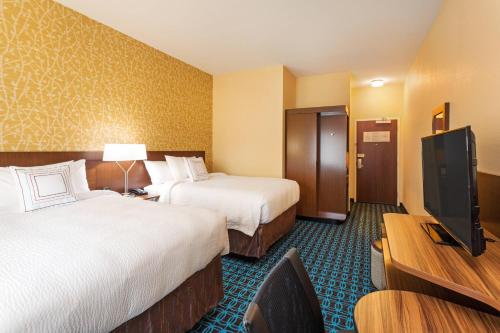 a hotel room with two beds and a flat screen tv at Fairfield Inn & Suites by Marriott Johnson City in Johnson City
