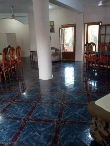 a room with a blue tiled floor with a table and chairs at New Oasis 2 in Bawiti