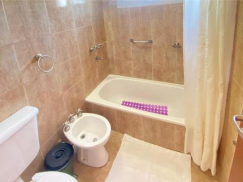 a bathroom with a toilet and a tub and a sink at Posada D`Lua in Villa Carlos Paz