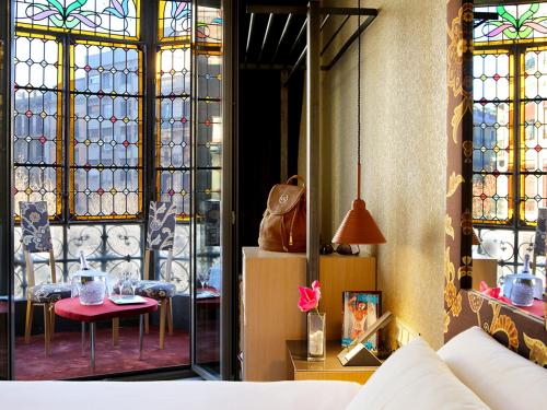 Habitación con vidrieras y mesa. en Axel Hotel Barcelona - Adults Only en Barcelona