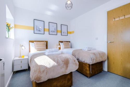 a bedroom with two beds and a door with twoitures at Westlea in Leeds