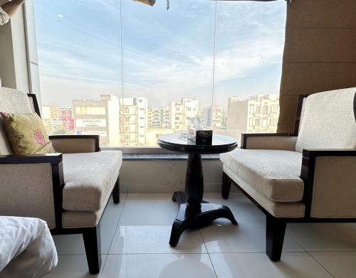 a room with two chairs and a table and a window at Mukhtar Homes Bahria Town Lahore in Lahore