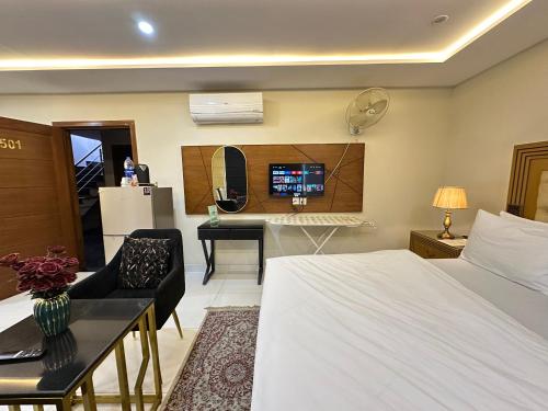 a bedroom with a bed and a desk with a computer at Mukhtar Homes Bahria Town Lahore in Lahore