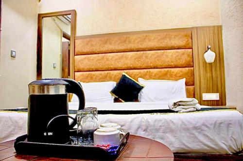 a hotel room with a bed and a coffee maker on a table at BLACKWOOD -140 Metres- Near Golden Temple in Amritsar