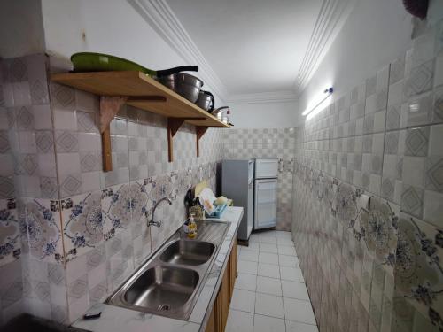 a kitchen with a sink and a refrigerator at TDD a2 in Douala