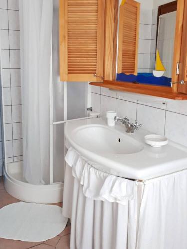 a white bathroom with a sink and a shower at Apartments Valic in Baška