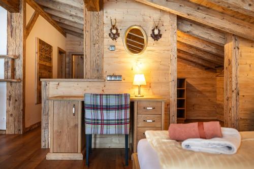 sypialnia w drewnianym domku z biurkiem i krzesłem w obiekcie Hotel Garni Ransburgerhof w mieście Flachau