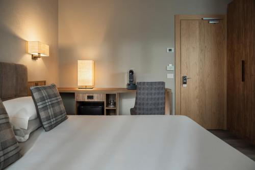 a hotel room with a bed and two chairs at Miramonti Park Hotel in Bormio