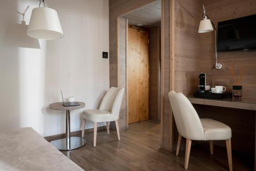 a kitchen with two white chairs and a table at Miramonti Park Hotel in Bormio