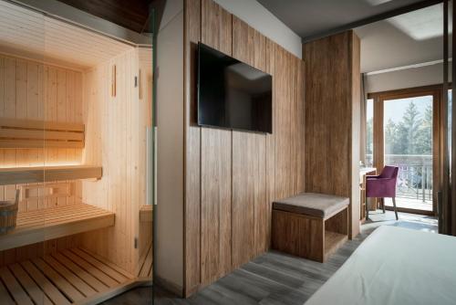 a room with a tv on a wooden wall at Miramonti Park Hotel in Bormio