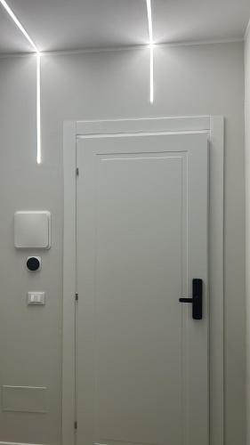 a white door in a white wall with a light at Les Suites di Parma - Cavour in Parma