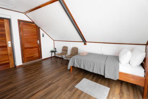 a bedroom with a bed and two chairs in a room at Boutique Hotel Peperpot in Meerzorg