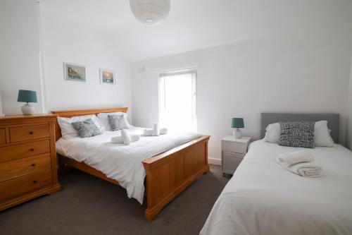 a bedroom with two beds and a window at 2 Bedroom House By Travel Lets Holiday Homes Belfast In City Centre With Free Parking in Belfast