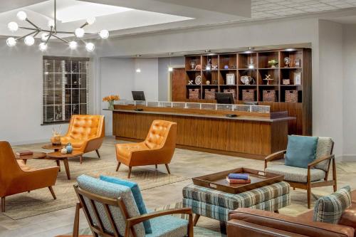 a lobby with a waiting area with chairs and a reception desk at Four Points by Sheraton Kalamazoo in Kalamazoo
