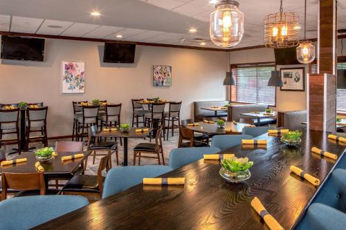 a dining room with tables and chairs and a bar at Four Points by Sheraton Kalamazoo in Kalamazoo