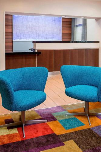 two blue chairs sitting in a room with a screen at Fairfield Inn & Suites Tyler in Tyler