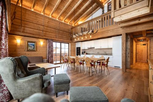 salon ze stołem i krzesłami oraz kuchnię w obiekcie Hotel Garni Ransburgerhof w mieście Flachau