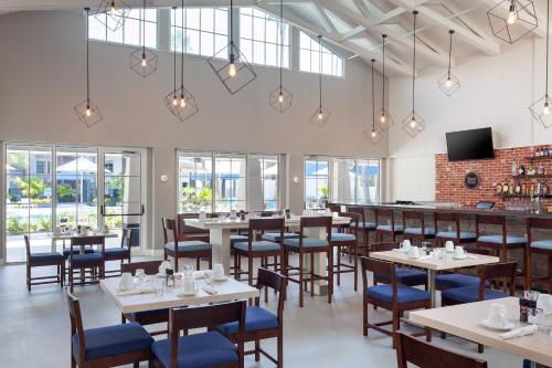 a restaurant with tables and chairs and a bar at Four Points by Sheraton Orlando Convention Center in Orlando