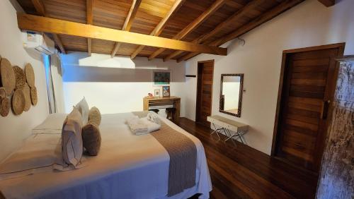 a bedroom with a large bed in a room with wooden ceilings at Pousada Vila do Mar in Caraíva