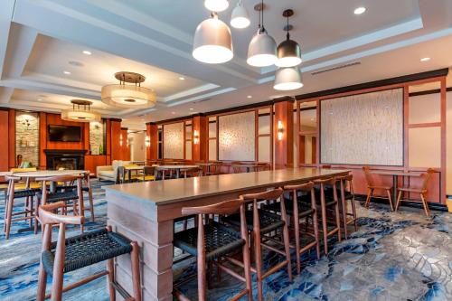 a bar in a restaurant with tables and chairs at Fairfield Inn & Suites Columbus in Columbus