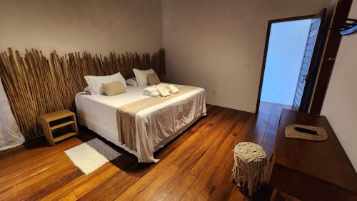 a bedroom with a bed with white sheets and pillows at Pousada Vila do Mar in Caraíva