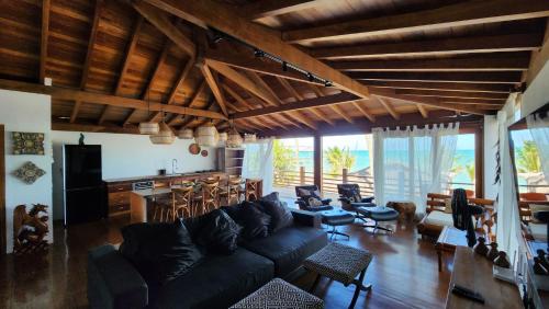 a living room with a black couch and a table at Pousada Vila do Mar in Caraíva