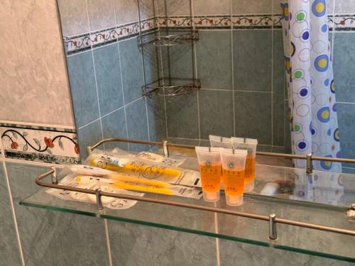Un estante de vidrio en un baño con dos vasos. en Nuri, en Karakol