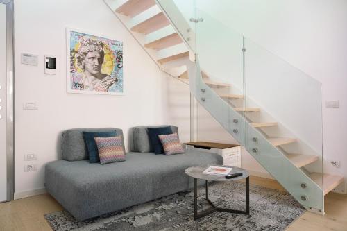 a living room with a couch and a staircase at Compagnoni12 Luxury penthouse with private Jacuzzi and SPA in Milan