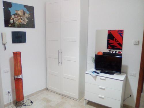 a bedroom with a closet with a tv and a cabinet at Casa Maddò in Castelbuono