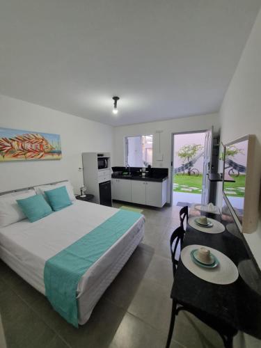 Un dormitorio con una cama grande y dos mesas. en RC FLATS apts 02 e 04, en Tamandaré