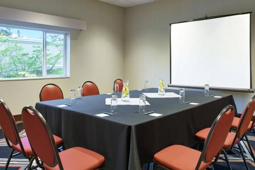 a conference room with a table and chairs and a screen at Four Points by Sheraton Bellingham Hotel & Conference Center in Bellingham