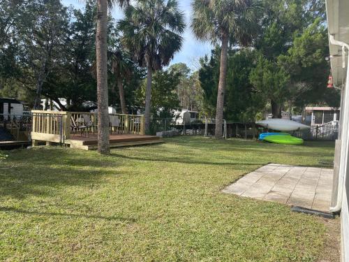 a yard with a deck and a green frisbee at ChassRiverVibes in Homosassa