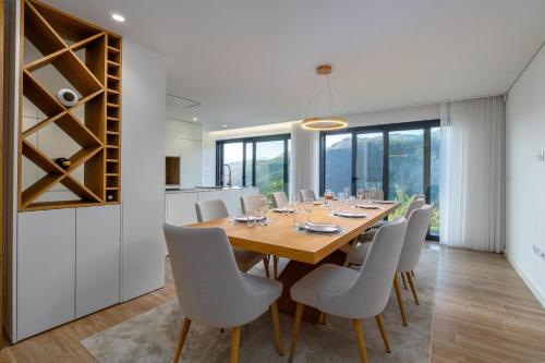 a dining room with a wooden table and white chairs at Waterfall View in Paradise in Louredo