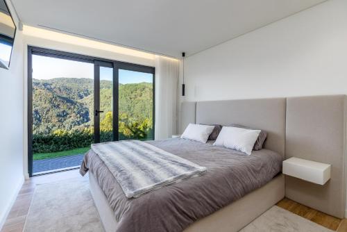 a bedroom with a bed and a large window at Waterfall View in Paradise in Louredo