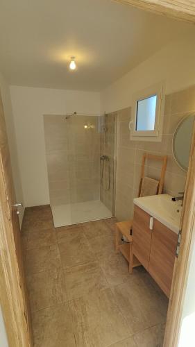 une salle de bain avec une douche, un lavabo et un miroir dans l'établissement la petite villa, à Port-de-Bouc