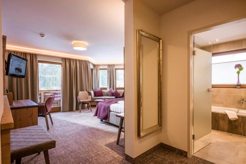 a hotel room with a bed and a bathroom at Hotel Bergkristall in Oberau