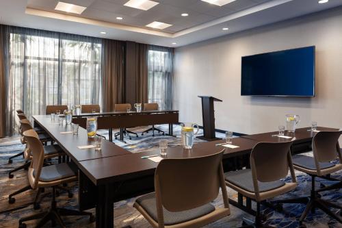 a conference room with tables and chairs and a flat screen tv at Fairfield Inn & Suites by Marriott Wellington-West Palm Beach in Wellington