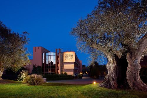 ein Gebäude mit einem Baum vor einem Gebäude in der Unterkunft Four Points by Sheraton Siena in Siena