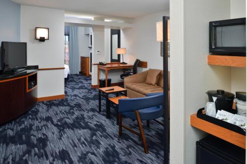 a hotel room with a couch and a television at Fairfield Inn & Suites Santa Cruz - Capitola in Capitola